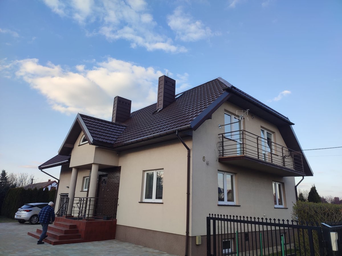 Dom jednorodzinny z dachem z brązowej blachodachówki - materiał i montaż KMK Dachy
